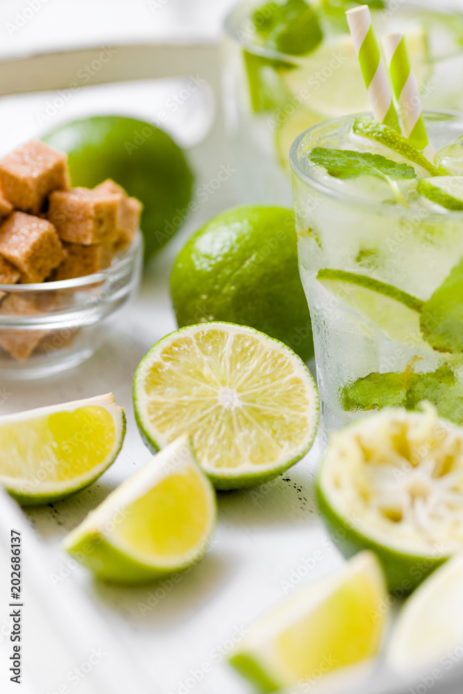 Summer refreshing cocktail caipirinha with lime and mint on white wooden vintage background. Summer refreshing cocktail caipirinha with lime and mint on white wooden vintage background.