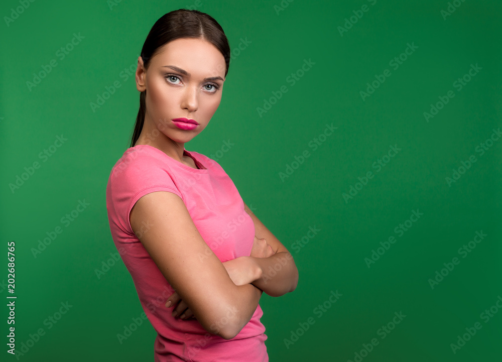 Waist up portrait of attractive lady standing with severe face. Copy space in right side. Isolated on background Waist up portrait of attractive lady standing with severe face. Copy space in right side. Isolated on background
