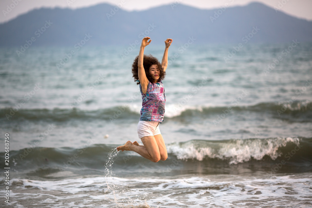 Girl jumping on the sea beach.