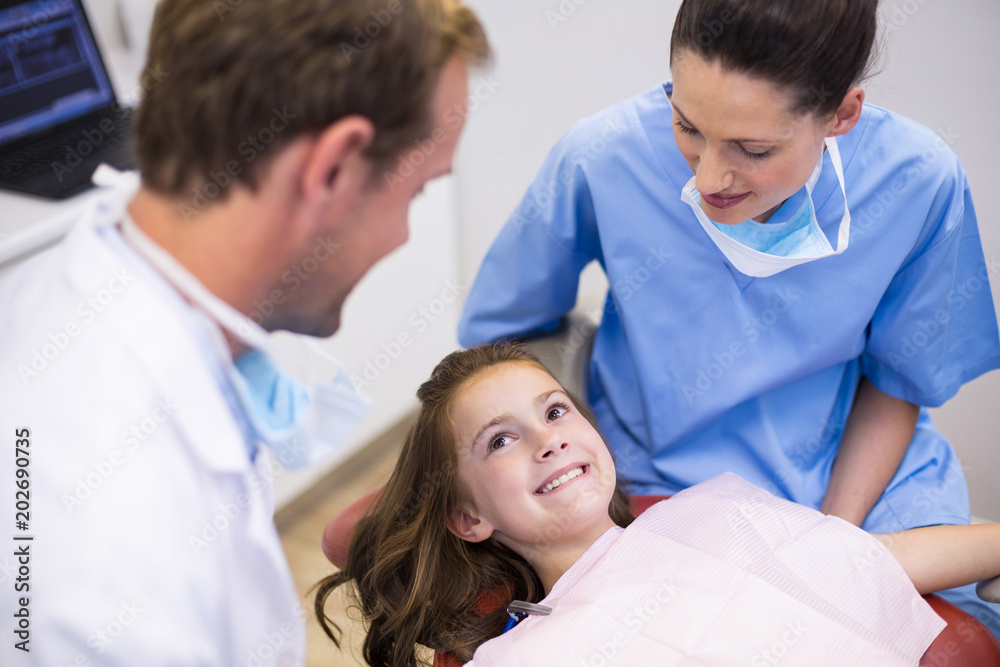 Smiling dentists interacting with young patient Smiling dentists interacting with young patient