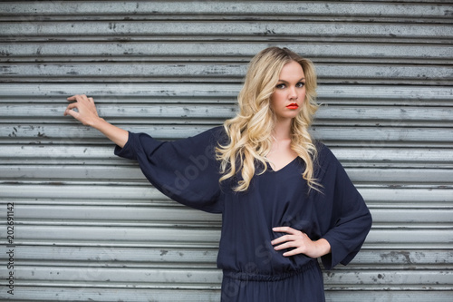 Serious sexy blonde wearing classy dress posing outdoors