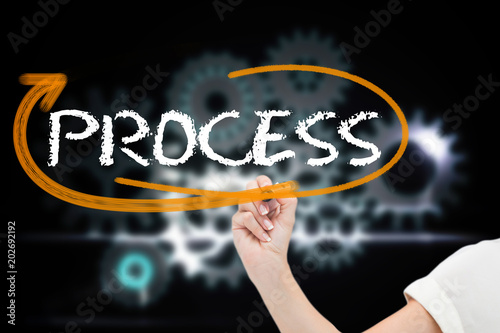 Cuadro en lienzo Businesswoman writing the word process against cogs and wheels graphic