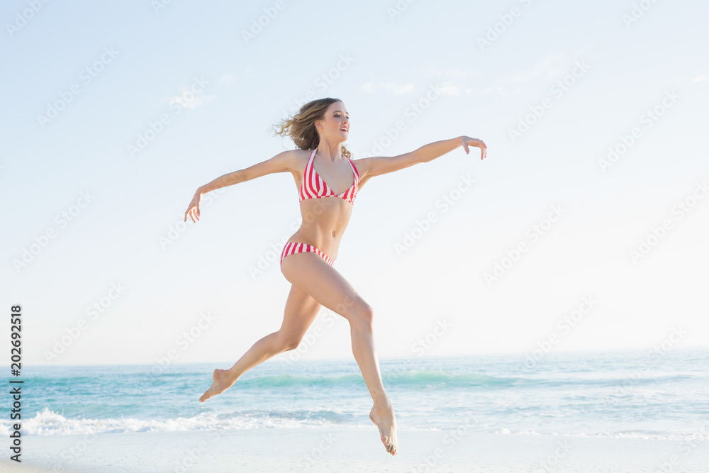Pretty blonde woman jumping on the beach Pretty blonde woman jumping on the beach