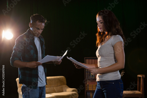 Actors reading their scripts on stage photo