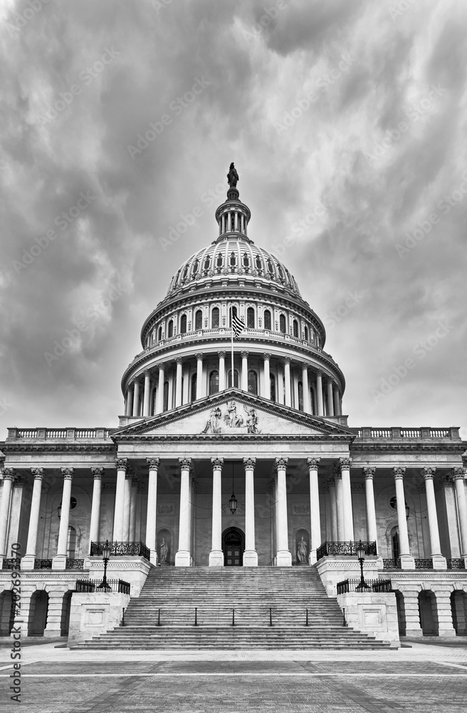 United States Capitol Building facade and empty plaza on a dark cloudy day, no people visible, Washington D.C., USA