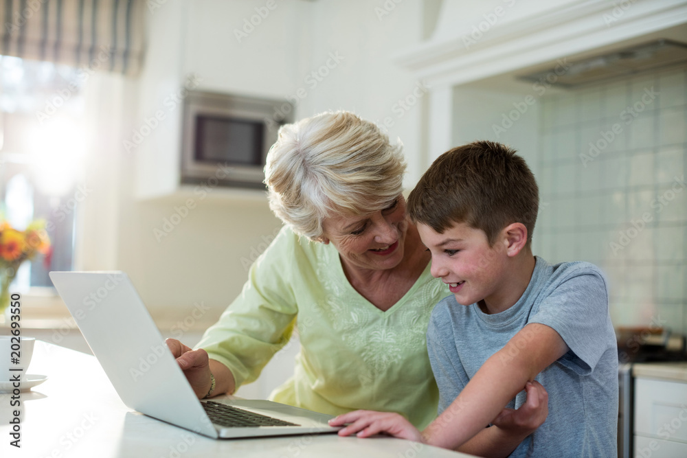 Grandson using laptop with grandmother Grandson using laptop with grandmother