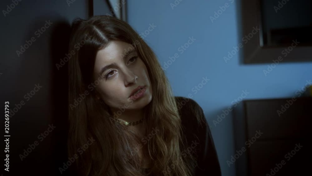 Sad And frightened Woman Sitting On The Floor In The Dark
