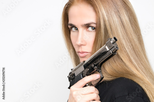 Dangerous blond woman with gun in hand