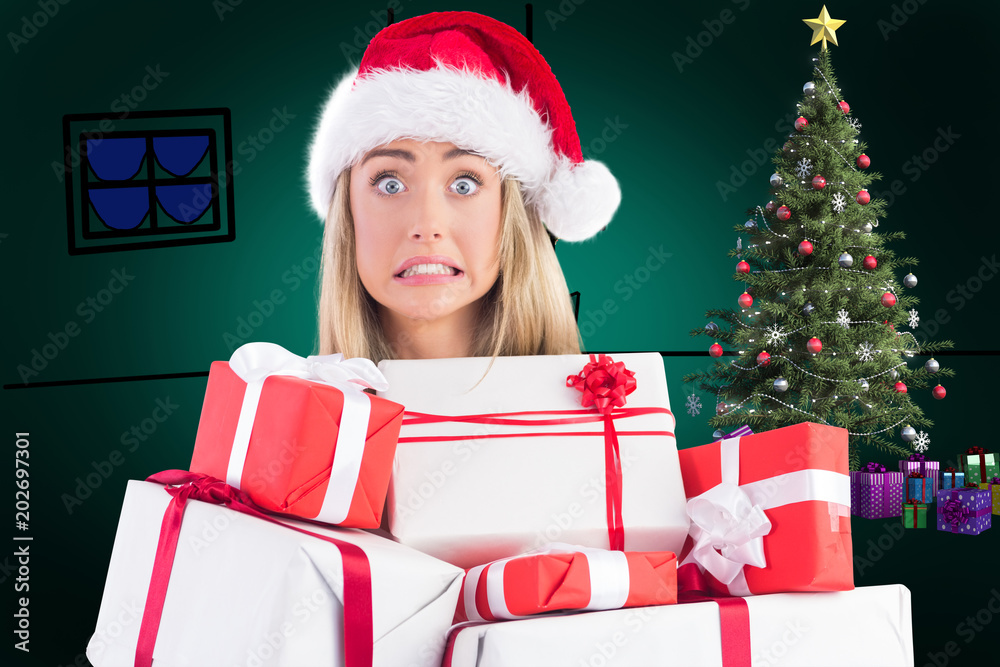 Festive blonde holding pile of gifts against green background with vignette Festive blonde holding pile of gifts against green background with vignette