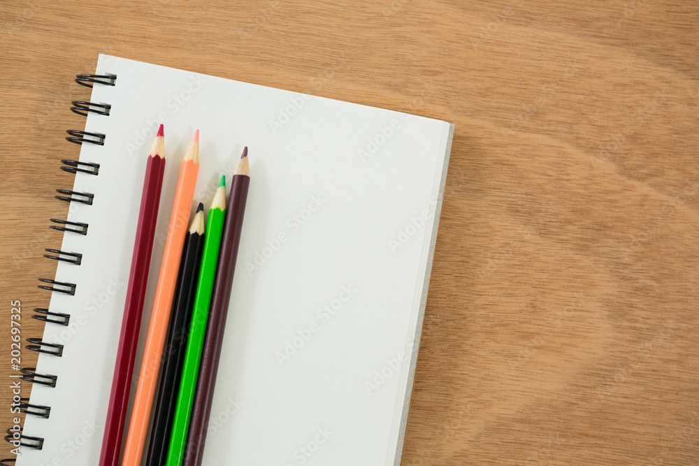 Colored pencils kept on the book Colored pencils kept on the book