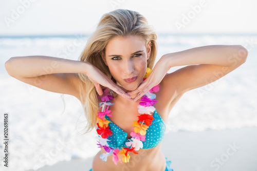 Sexy happy blonde in bikini wearing hawaii necklace posing