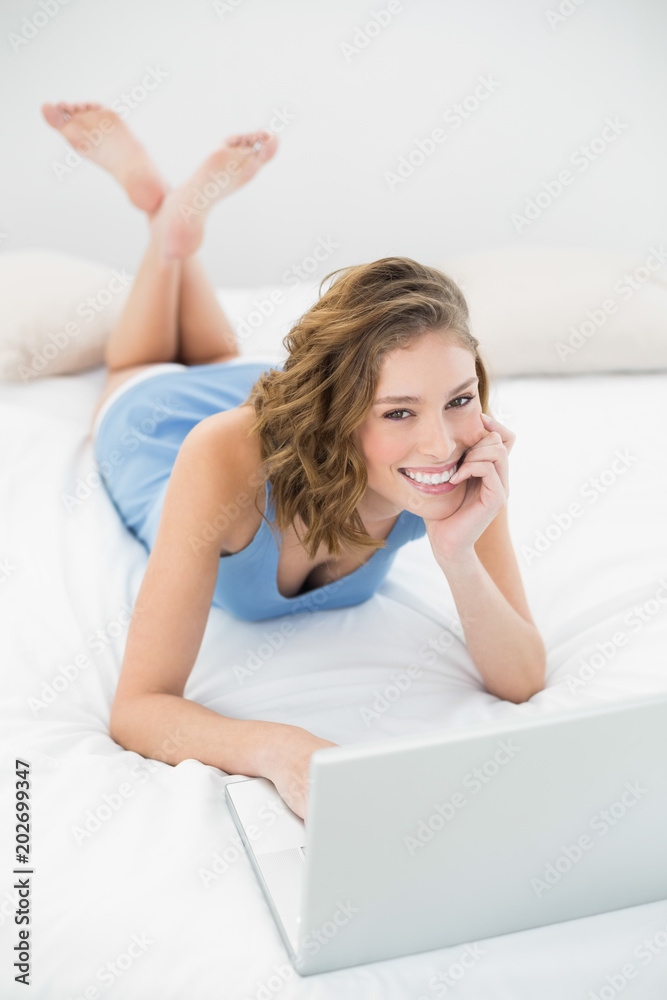 Beautiful happy woman using her notebook smiling at camera Beautiful happy woman using her notebook smiling at camera