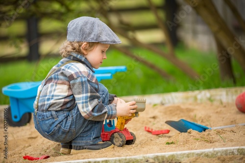 Foto Small caucasian boy playing in sandpit