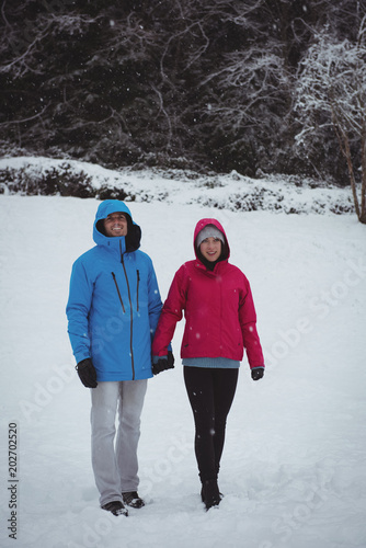 Couple walking in snowy forest