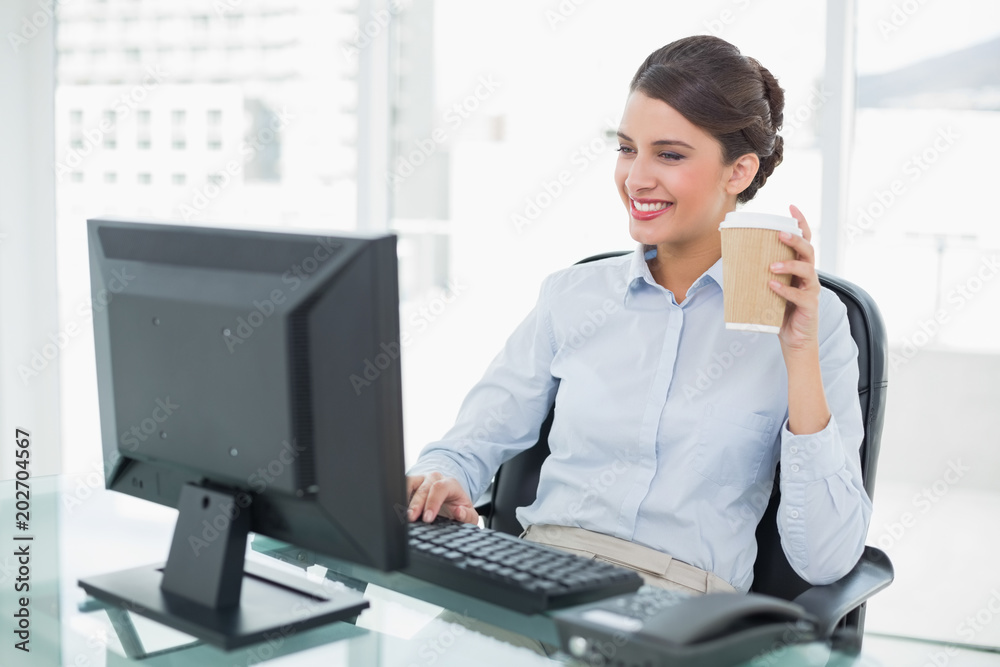 Smiling classy brown haired businesswoman holding a cup of coffee Smiling classy brown haired businesswoman holding a cup of coffee