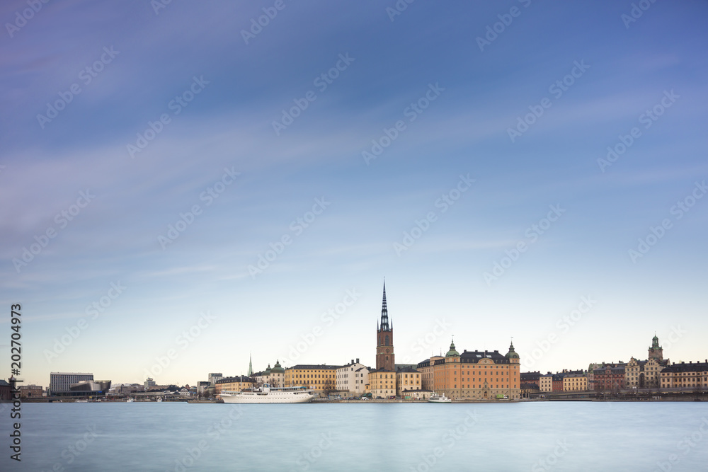 Beautiful scenic panorama of the Old City (Gamla Stan) cityscape pier architecture with historic town houses with colored facade in Stockholm, Sweden. Creative long time exposure landscape photography