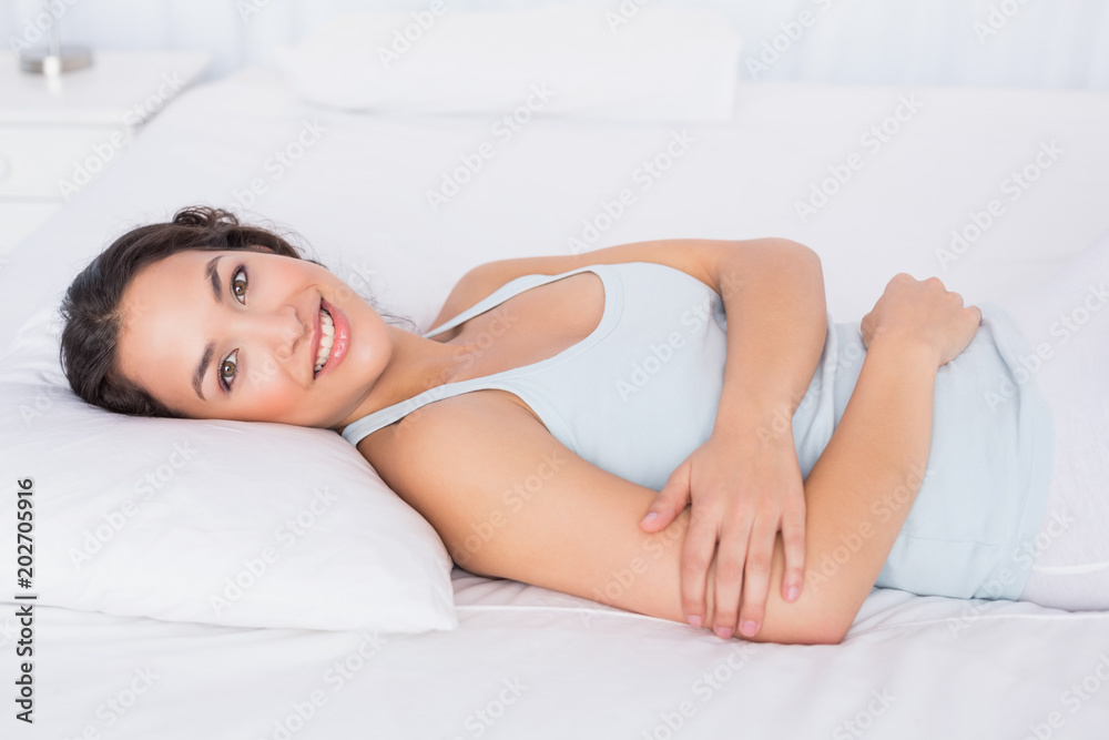 Smiling pretty young woman relaxing in bed Smiling pretty young woman relaxing in bed