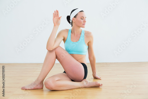 Woman doing the spine twisting pose at fitness studio