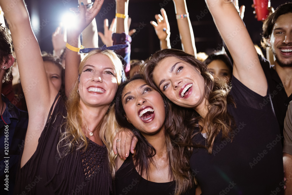 Cheerful female friends enjoying at music festival