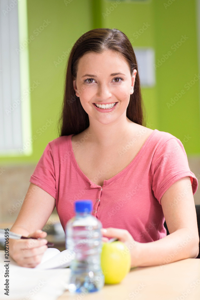Female student doing homework in library Female student doing homework in library