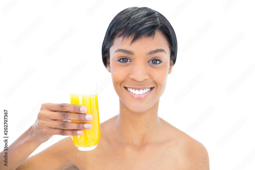 Dynamic black haired woman holding a glass of orange juice Dynamic black haired woman holding a glass of orange juice