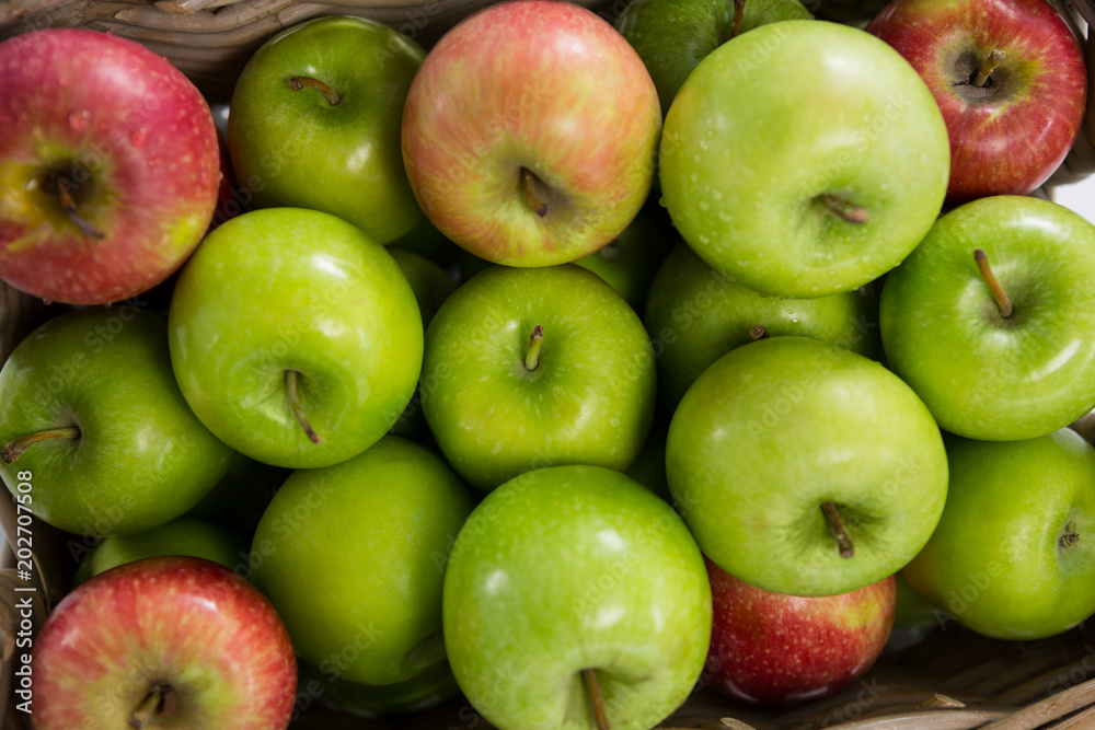 Red and green apples in wicker basket Red and green apples in wicker basket