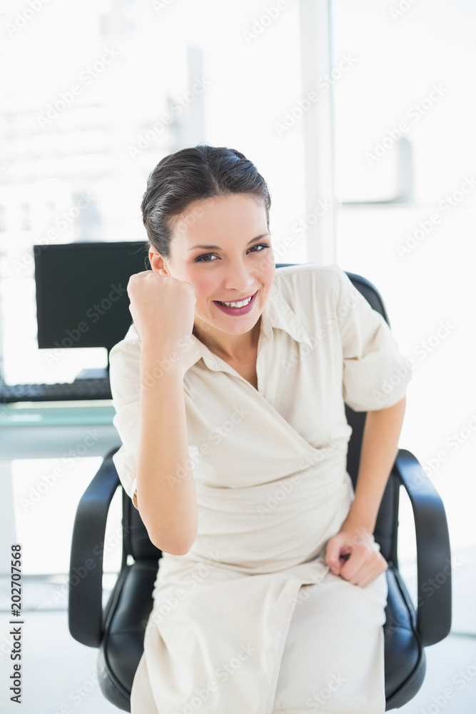 Victorious stylish brunette businesswoman raising her fist