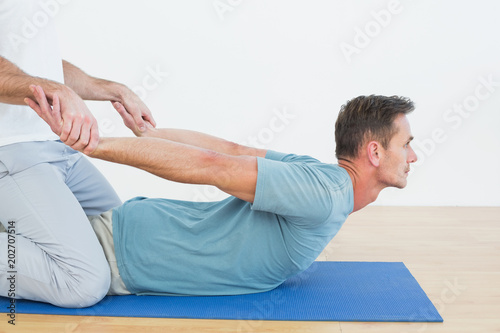 Physical therapist assisting man with stretching exercises