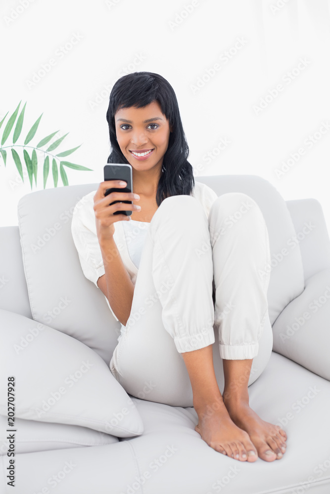 Delighted black haired woman in white clothes typing on her mobile phone Delighted black haired woman in white clothes typing on her mobile phone
