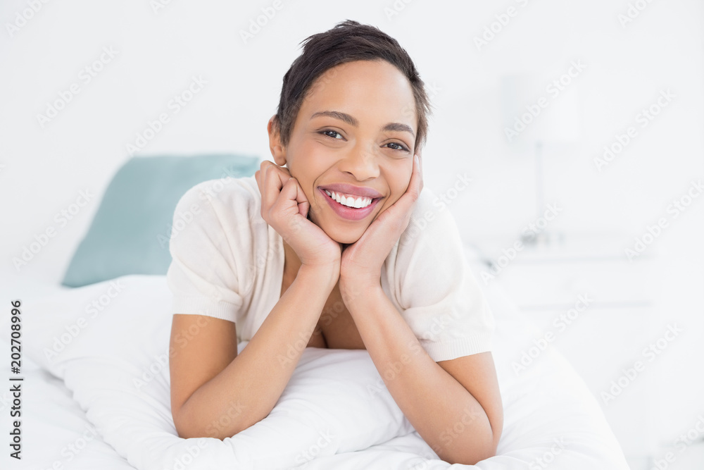 Smiling young woman relaxing in bed