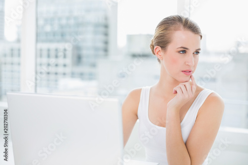 Pensive blonde using her laptop Free Download Pensive blonde using her laptop - GFXLoad