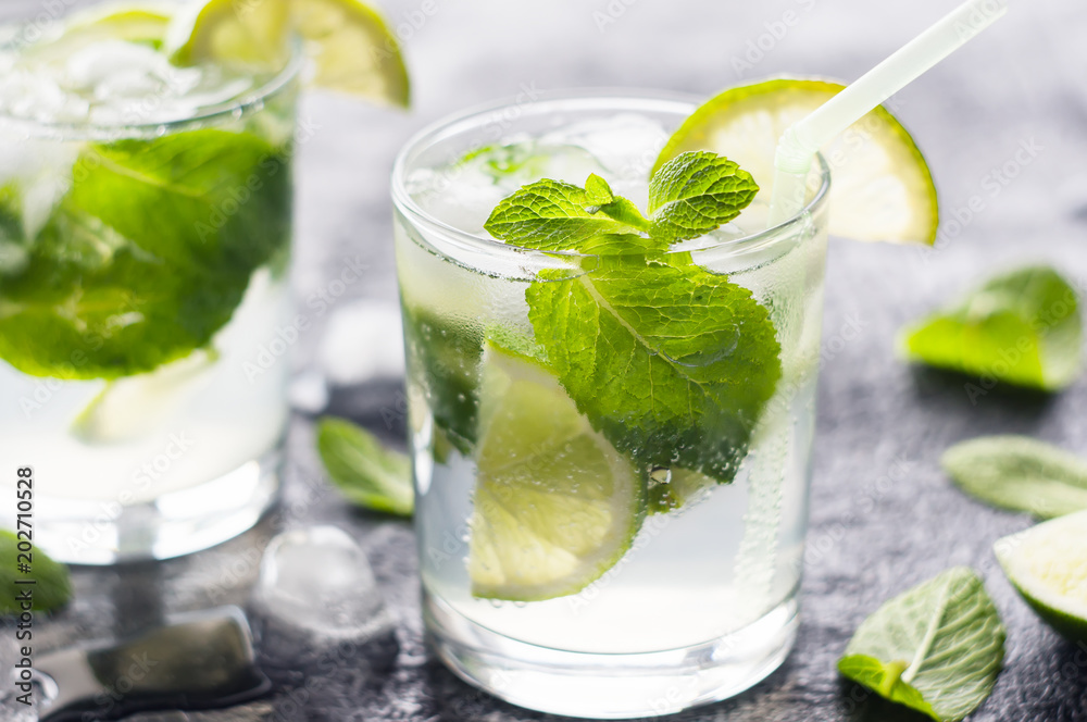 Mojito cocktail with lime and mint in glass at sunlight. Closeup photo. Mojito cocktail with lime and mint in glass at sunlight. Closeup photo.