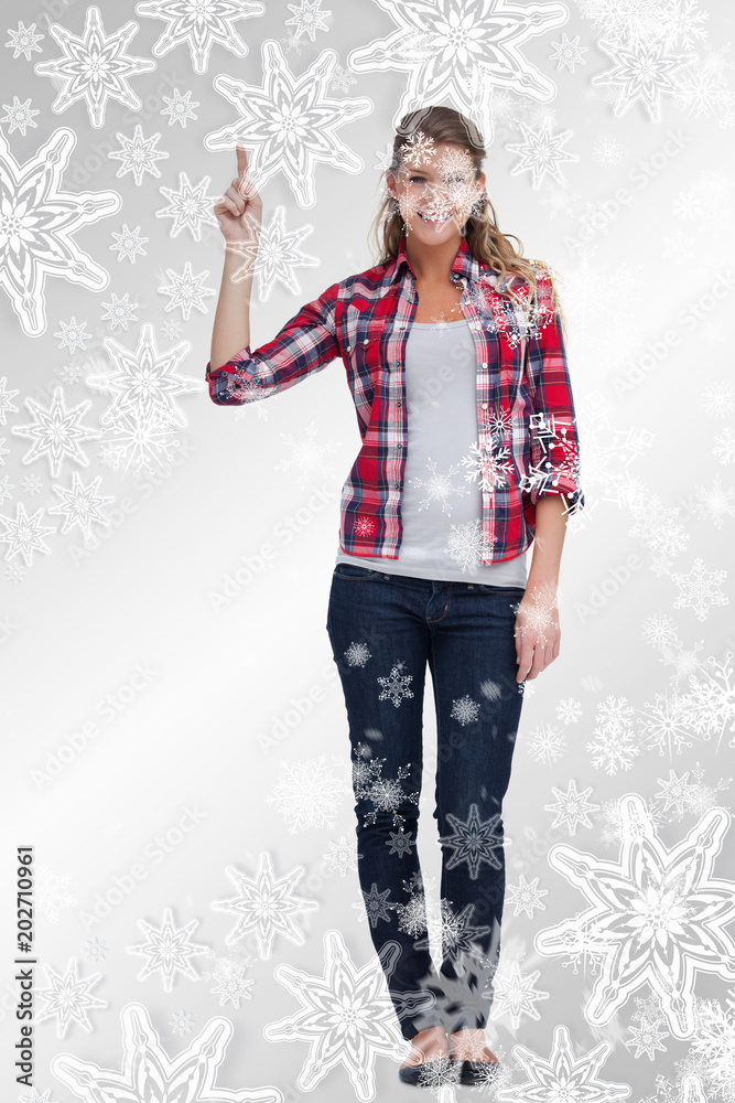 Portrait of a woman pointing at a copy space against snowflakes on silver Portrait of a woman pointing at a copy space against snowflakes on silver