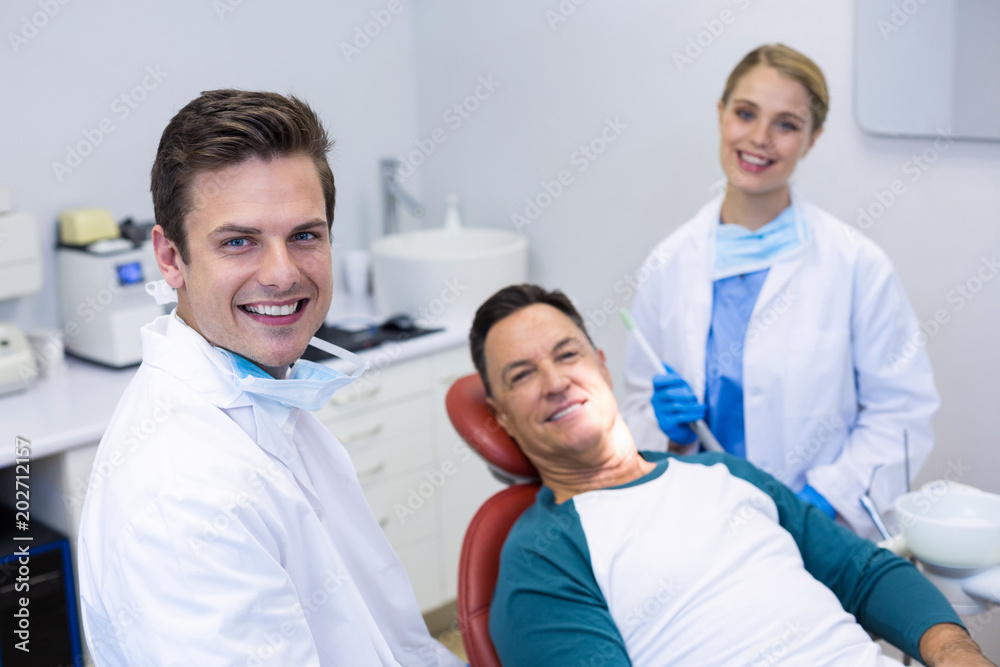 Portrait of smiling dentists and male patient Portrait of smiling dentists and male patient