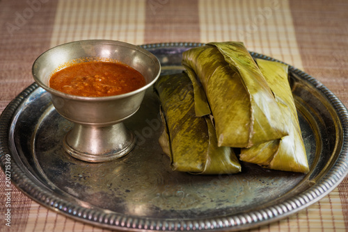 sticky rice wrapped in leaves and served with peanut sauce. Famous cuisine in Borneo. Brunei, Sarawak and Sabah. Called Kelupis. photo