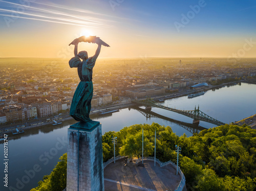 Budapest, Hungary - Aerial view of the beautiful Hungarian Statue of Liberty with Liberty Bridge and skyline of Budapest at sunrise with clear blue sky