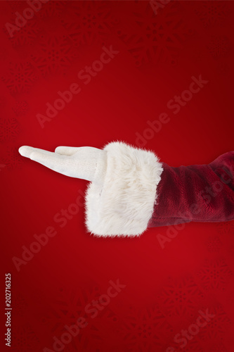 Santa Claus shows open hand against red background