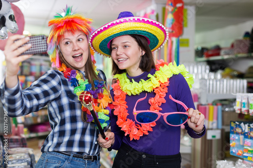 Girls taking selfie in store of festival accessories