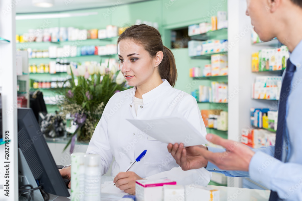 Woman pharmacist is recommending medicine for  male