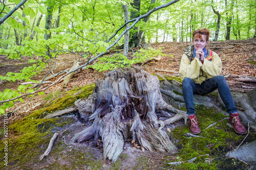 eine Frau sitzt im Wald und genießt die Natur
