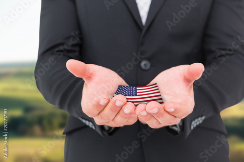 Businessman holding his hands out against scenic landscape