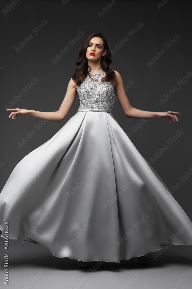 Young elegant woman in long silver dress.