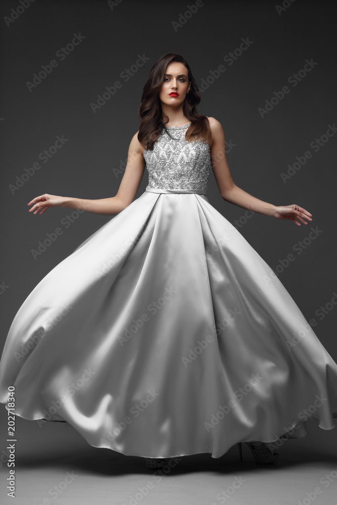 Young elegant woman in long silver dress.