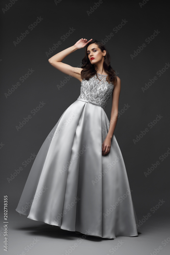 Young elegant woman in long silver dress.