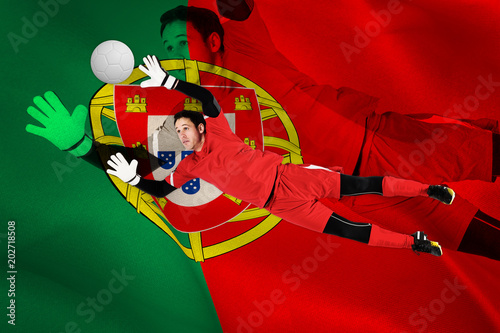 Fit goal keeper jumping up against digitally generated portugese national flag