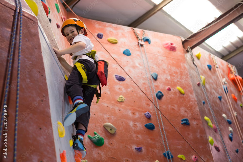 Obraz premium Portrait of determined boy practicing rock climbing
