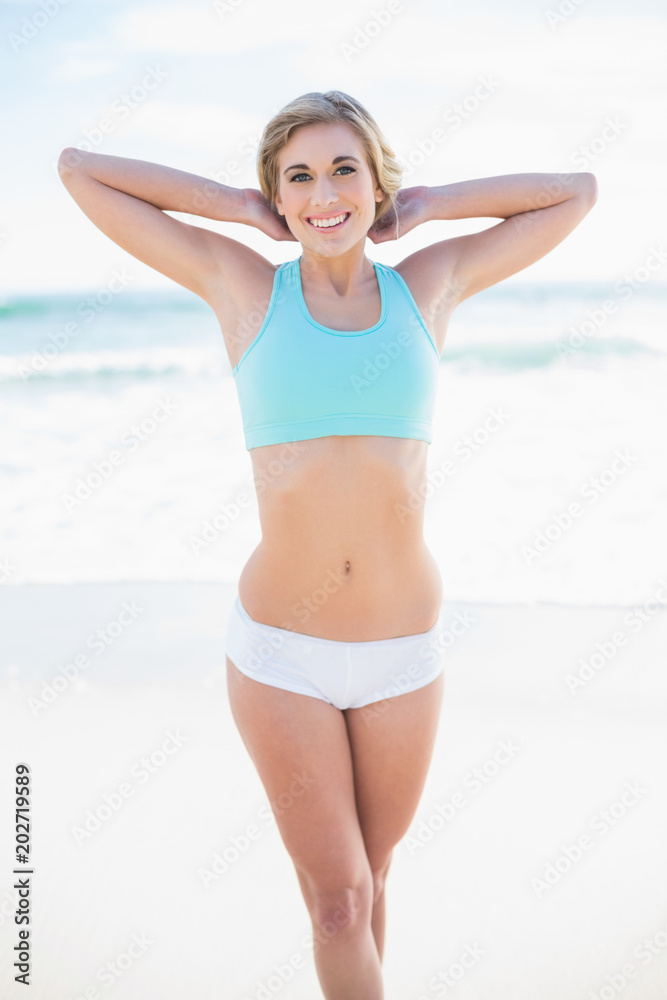 Cheerful blonde model in sportswear posing looking at camera