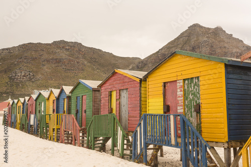 Multi colored wooden beach huts on sand © WavebreakmediaMicro