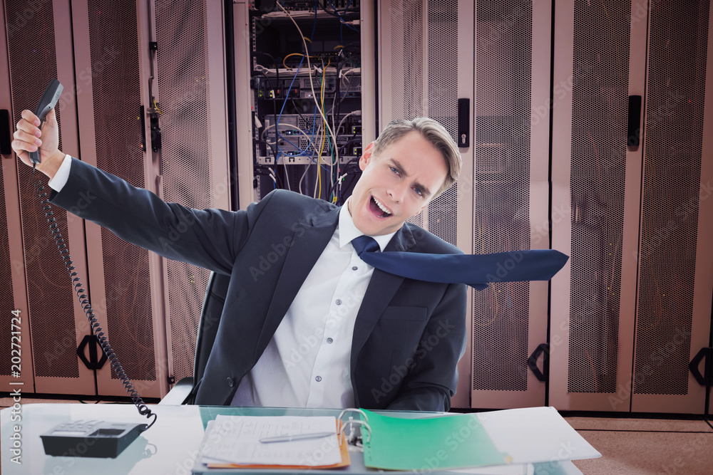 Φωτογραφία Businessman shouting as he holds out phone against data center