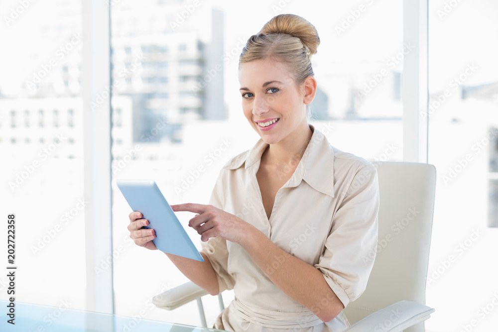 Pleased young blonde businesswoman using a tablet pc Pleased young blonde businesswoman using a tablet pc